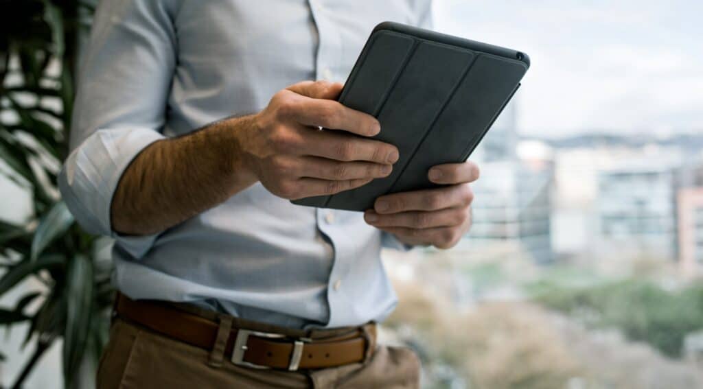 Business owner reviewing a tablet by an office window