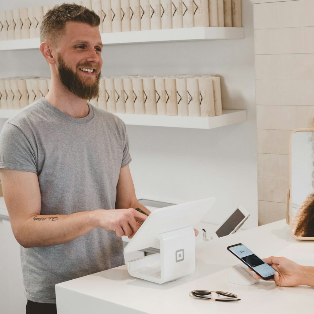 Small business owner serving a customer at a shop counter