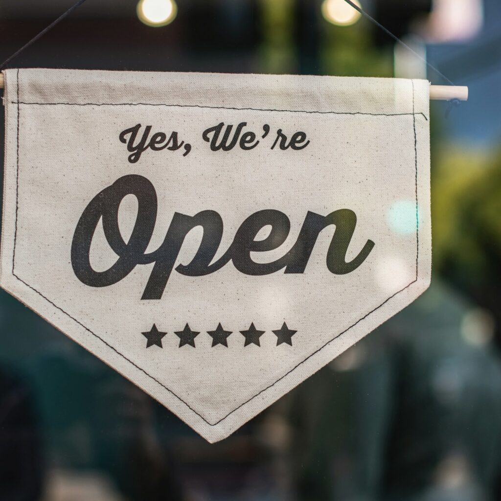 Yes, we're open sign hanging in a shop window