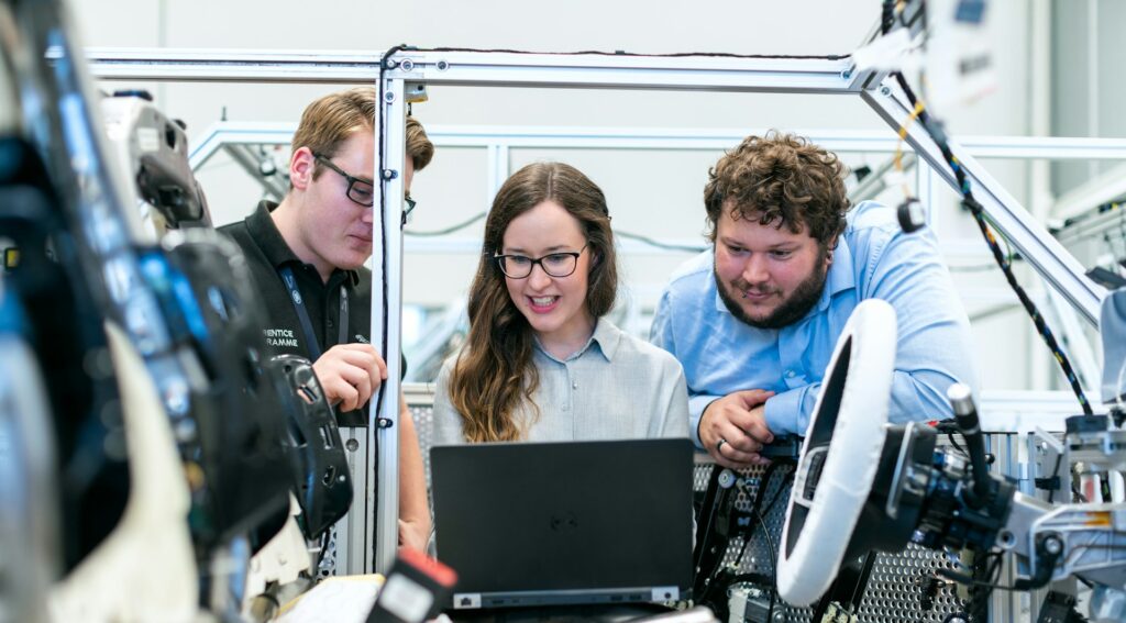 Engineering team testing software together at a workbench
