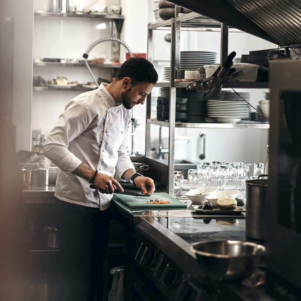 Chef chopping vegetables in a restaurant kitchen