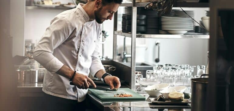 Chef chopping vegetables in a restaurant kitchen