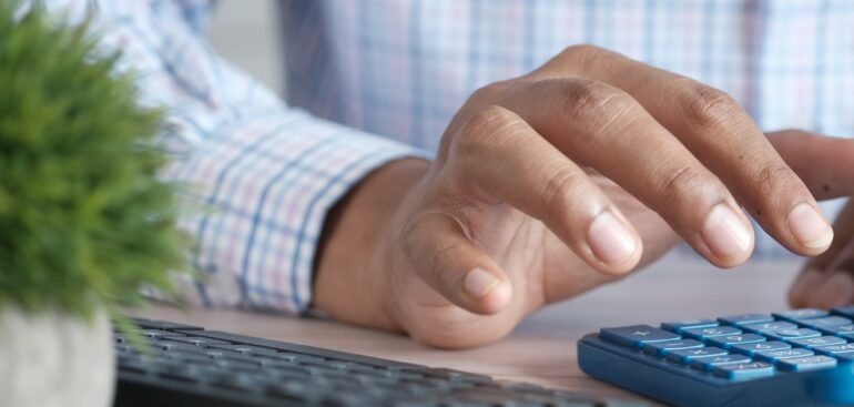 Business owner working through GST/HST figures on a calculator