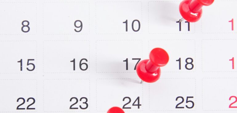 Calendar with red pins marking payment dates