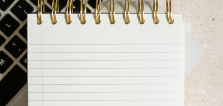 Laptop, notepad and calendar laid out for year-end planning
