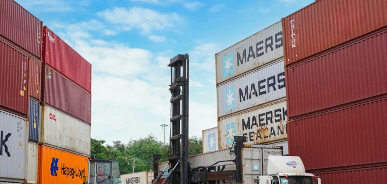 Forklift moving shipping containers at a port