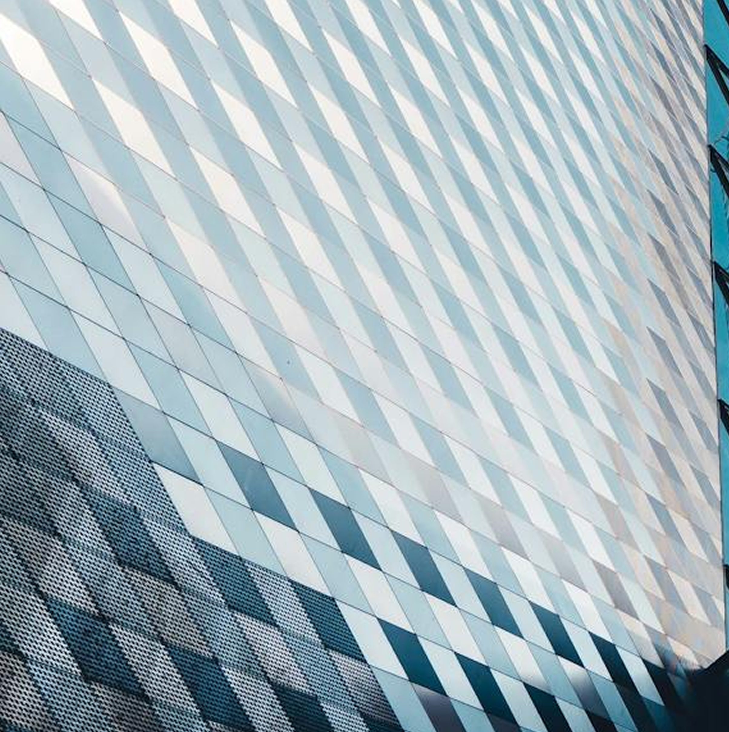 Modern glass office building against a blue sky